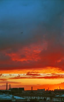 Industrial evening landscape with landing airplane