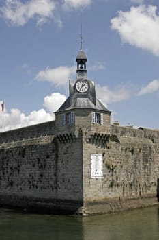 The southwest wall corner of the Ville Close, with clock and sunclock, in Brittany, North France.