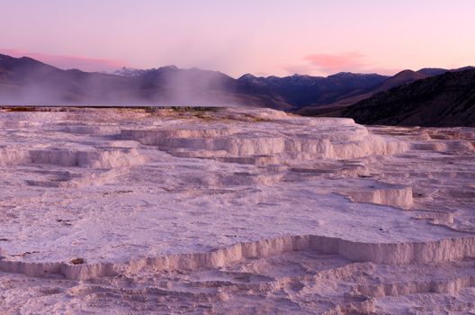 The Upper Terraces of Mammoth Hot Springs and distant mountains at sunrise, Yellowstone National Park, Wyoming, USA