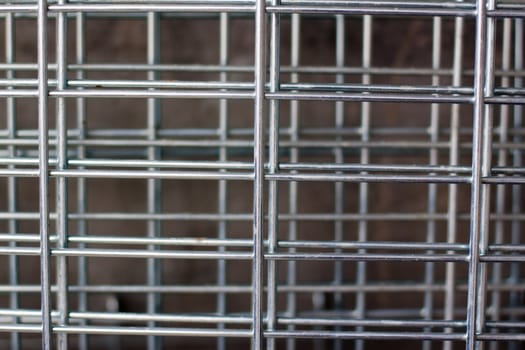 A metal lattice near a concrete wall
