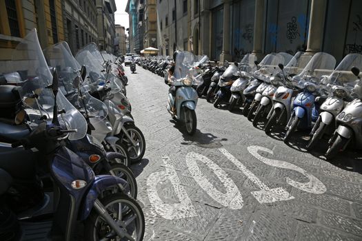 Lots of parked scooters and motorbikes in the center of Florence Italy.