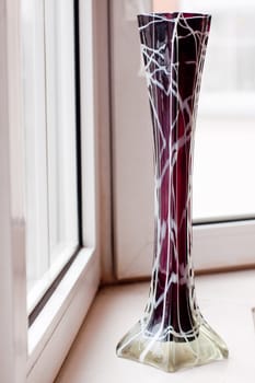 A vintage glass brow vase on a white sill
