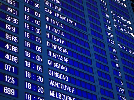 Blue flight information board in airport, selective focus.