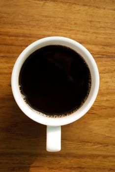 Hot coffee cup on wooden table in top view