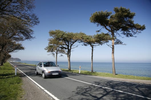 Speedy car along a coastal highway - Denmark - at springtime. Motion blur.