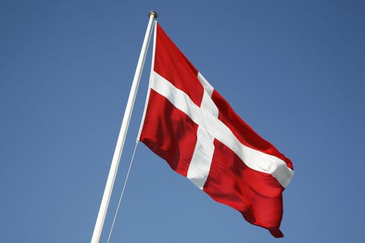The Danish flag - Dannebrog against a blue sky.