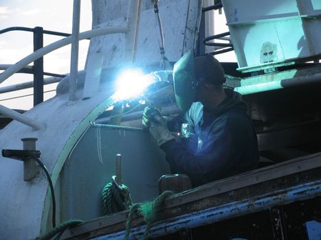 Welder repairing a fishing wessel.