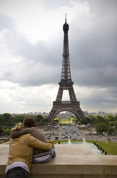 Young couple in love looking at the Eiffel Tower from Trocadero - Paris, France.