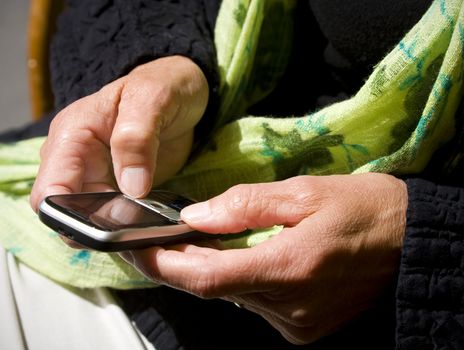 Senior writing a text message on her mobile phone.