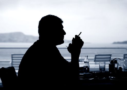 Man enjoying his first fag after breakfast at seaside - Croatia.