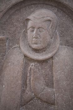 Detail of a very old gravestone in the Cathedral of Aarhus - Denmark. Focus on hands.