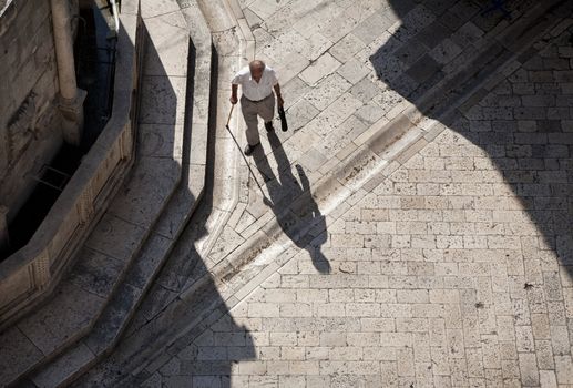 Shopping in the morning. Male senior seen from the town wall on his was to the morning market - Dubrovnik, Croatia.