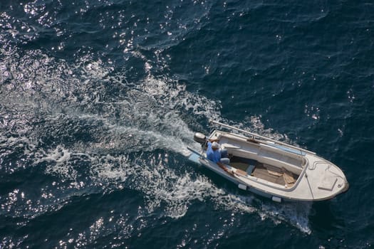 Croatian mature male in his motor boat seen from above at summertime.