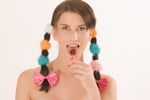 Girl with colorful braids licking a lollipop