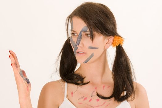 Young woman painting with paint on his face and hands