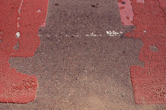 Fragment of asphalt road with red pointed pedestrian crossway.