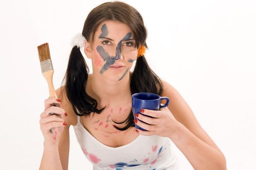 Young woman with paint makes coffee break and have a cup in his hand