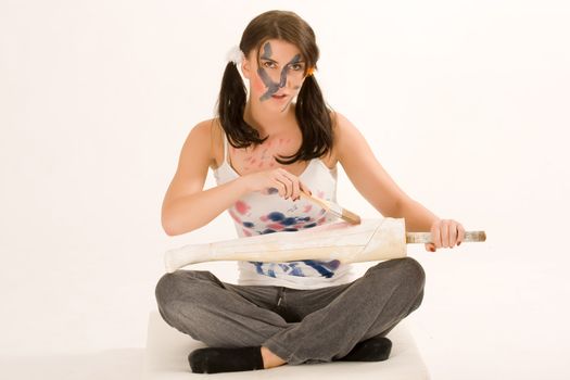 Young woman painting with paint on his face and hands