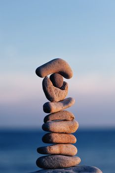 Pile of long pebbles in the balance on the seacoast