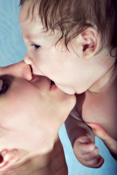 Beautiful baby kissing his mother. Portrait of a closeup
