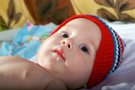 Closeup portrait of beautiful baby face on bed.