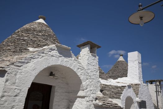 Trulli roofs against a blue sky. Alberobello, Apulia - Italy. A trullo is a traditional Apulian stone dwelling with a conical roof. The style of construction is specific to Itria Valley.
