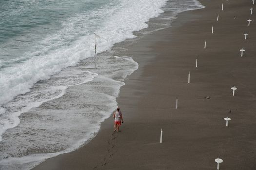 Mature man seen from above walking along the coast of Amalfi in the region of Campania, Italy