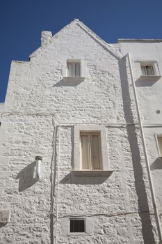 White painted building againt a nice blue September sky - Martina Franca, Apulia - Italy.