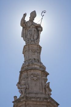 Saint Oronzo on top of his column in the middle of the square in Ostuni. His is called the first bishop of Lecce - Apulia, Italy.