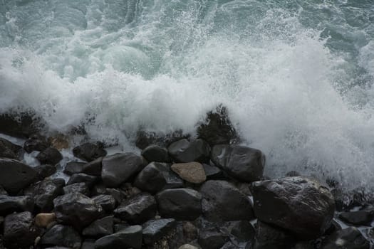 Ocean wave splashing against the stony beach.