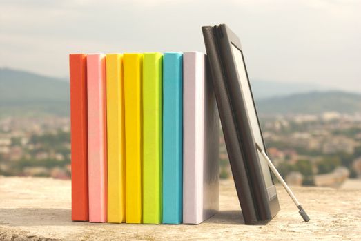 Row of colorful books with electronic book reader