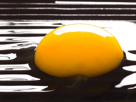 close up of a raw egg on a grill