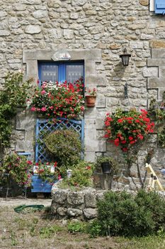 Plouharnel, house with blue windows and flowers, Brittany, North France.  Plouharnel, Haus mit blauen Fenstern und Blumen