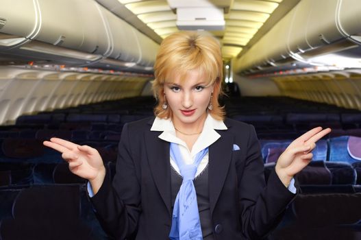 air hostess gesturing in the empty airliner cabin