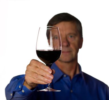Senior retired male with a glass of red wine with the man out of focus