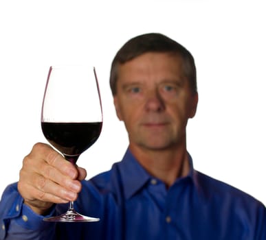 Senior retired male with a glass of red wine with the man out of focus