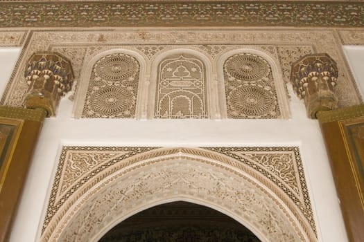 Ornate entrance arch and doorway inside the 19th century El Bahia Palace in Marrakesh, Morocco.