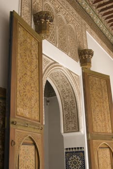 Ornate entrance arch and doorway inside the 19th century El Bahia Palace in Marrakesh, Morocco.