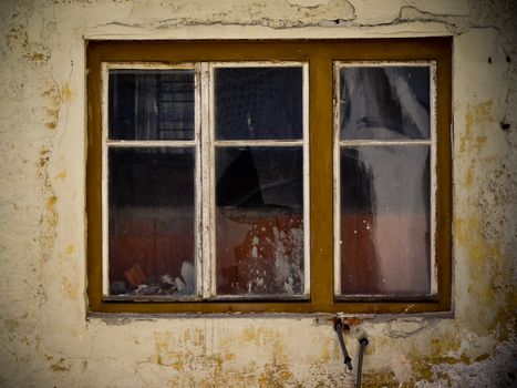 Old damaged window on a naked, dirty wall