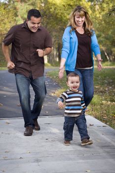 Happy Young Mixed Race Ethnic Family Walking In The Park.