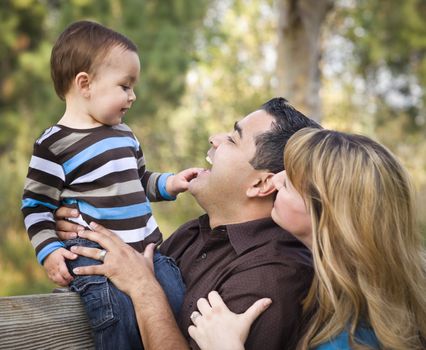 Happy Mixed Race Ethnic Family Having Fun Playing In The Park.