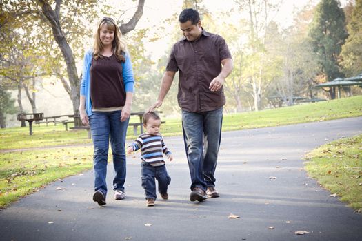 Happy Young Mixed Race Ethnic Family Walking In The Park.