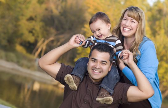 Happy Mixed Race Ethnic Family Posing for A Portrait in the Park.