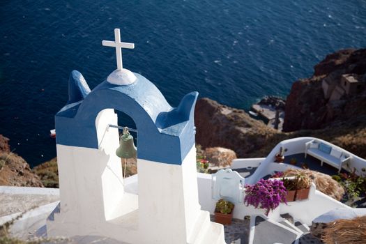 Scenic orthodox chapel in Oia, Santorini over blue sea