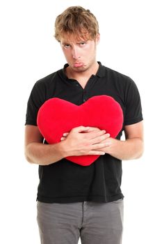 Unhappy love. Funny image of sad broken heart valentines day man holding red heart isolated on white background.