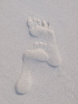 Closeup of fooprints on a sandy beach
