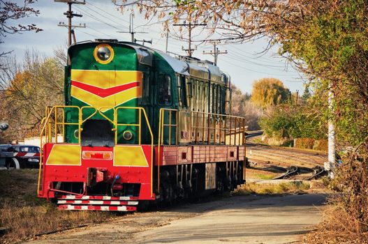 It is green a red diesel train on the railway