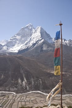Prayer flags on a ridge overlooking the fields and village of Dingboche (4410 Metres) on the trekking route to Everest Base Camp, Nepal