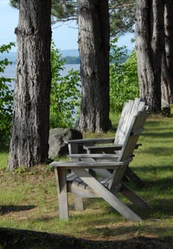 Two Adirondak chairs overlooking the lake.
