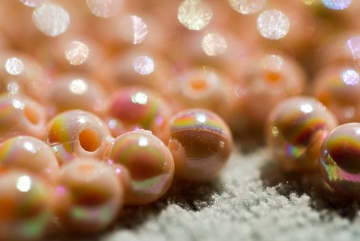 close up of beige colored beads shine under sunlight in on blue cloth